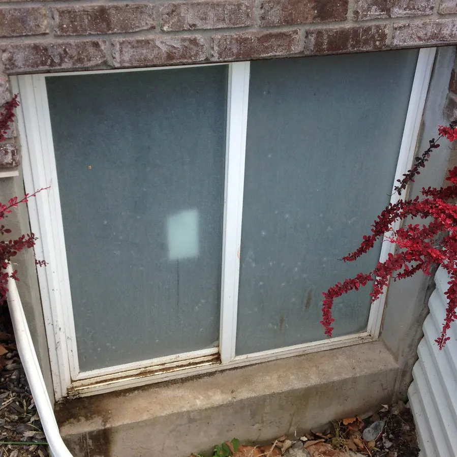 a dirty window with hard water stains before having the windows cleaned.