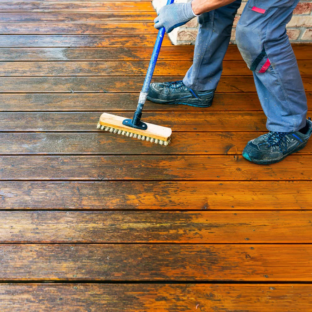 A before and after look of a dirty and clean wood deck.