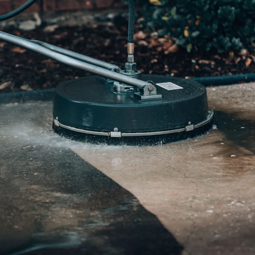Before and after images of an asphalt driveway cleaned by Veteran Cleaners in Arlington, VA.