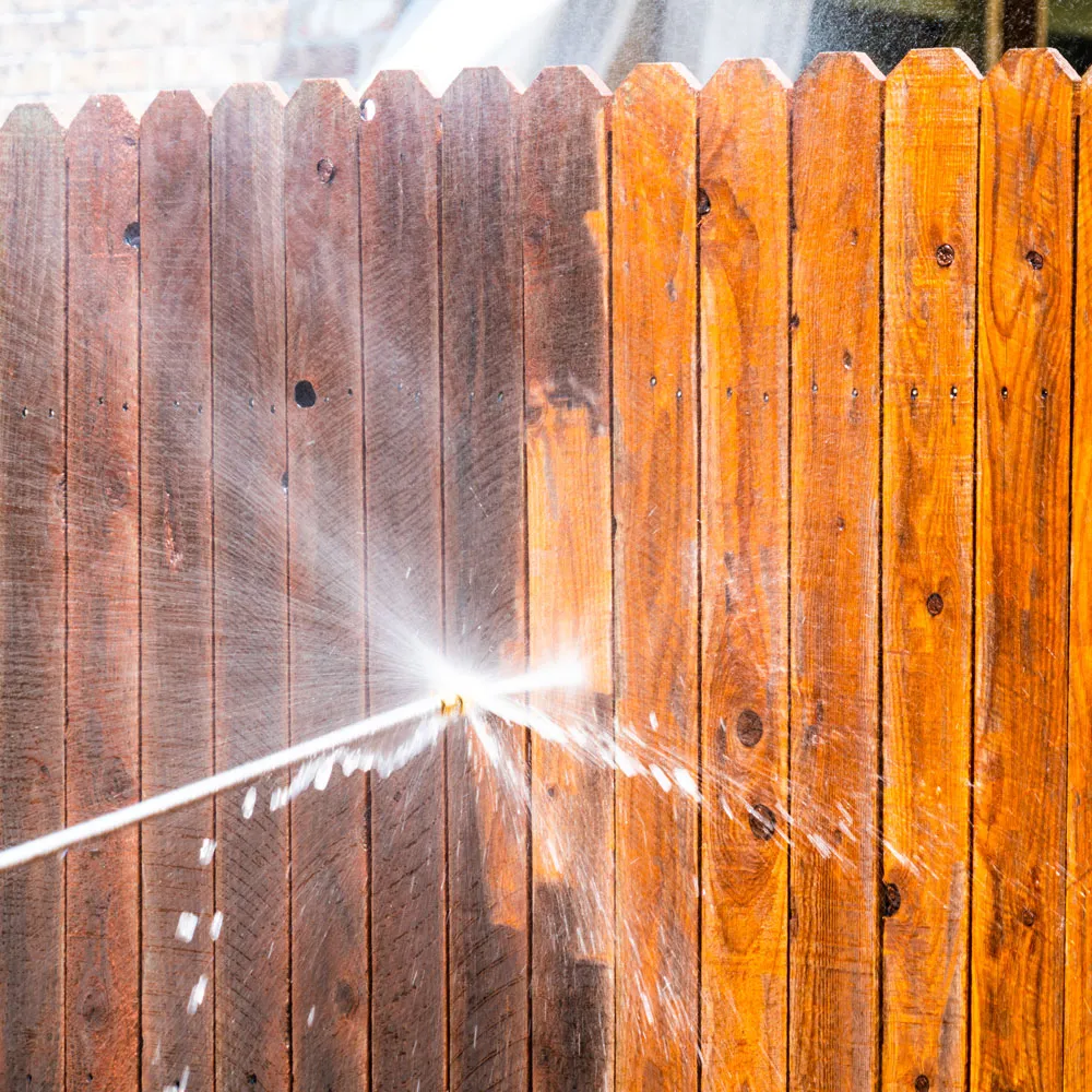 A before and after look of a wood fence being cleaned.